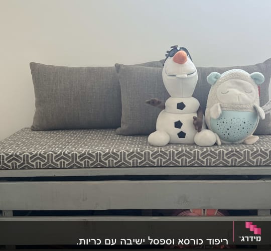 כריות אפורות על ספסל עם ריפוד גיאומטרי